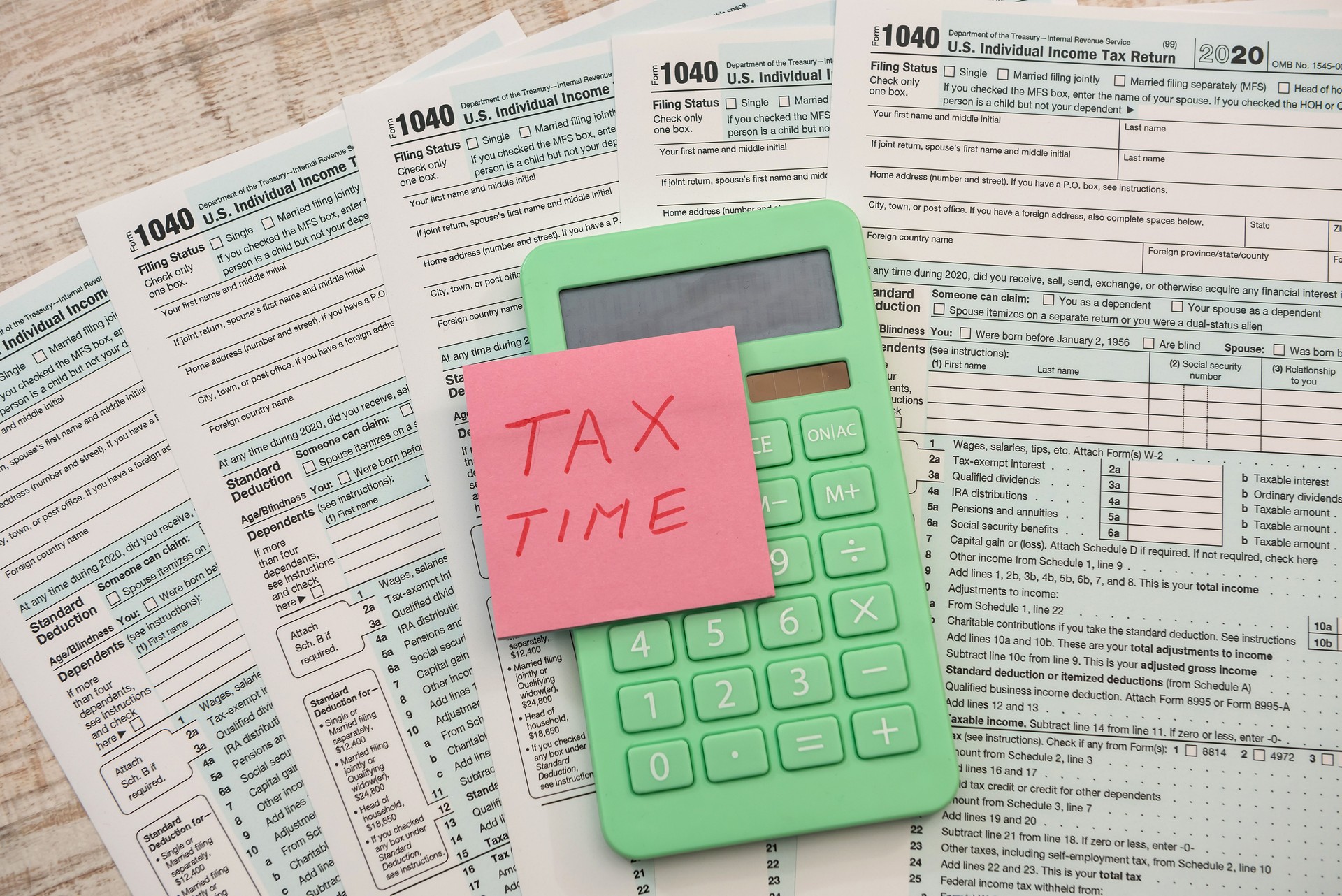 text tax time on sticker with calculator on 1040 tax form